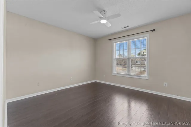 a view of an empty room with a ceiling fan