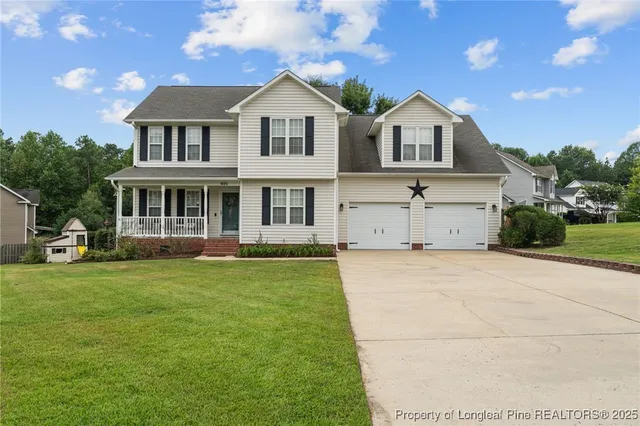 a front view of a house with a garden and yard