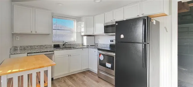 a kitchen with stainless steel appliances a refrigerator sink and cabinets