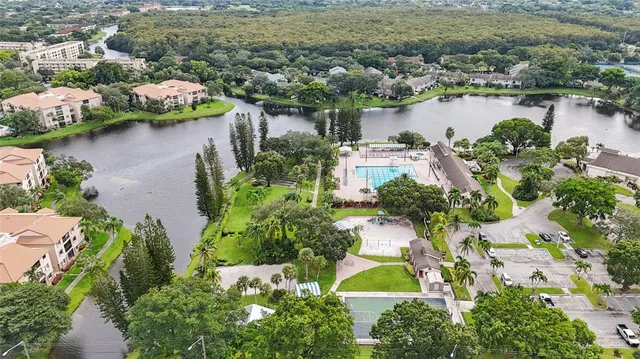 an aerial view of residential houses with outdoor space and lake view