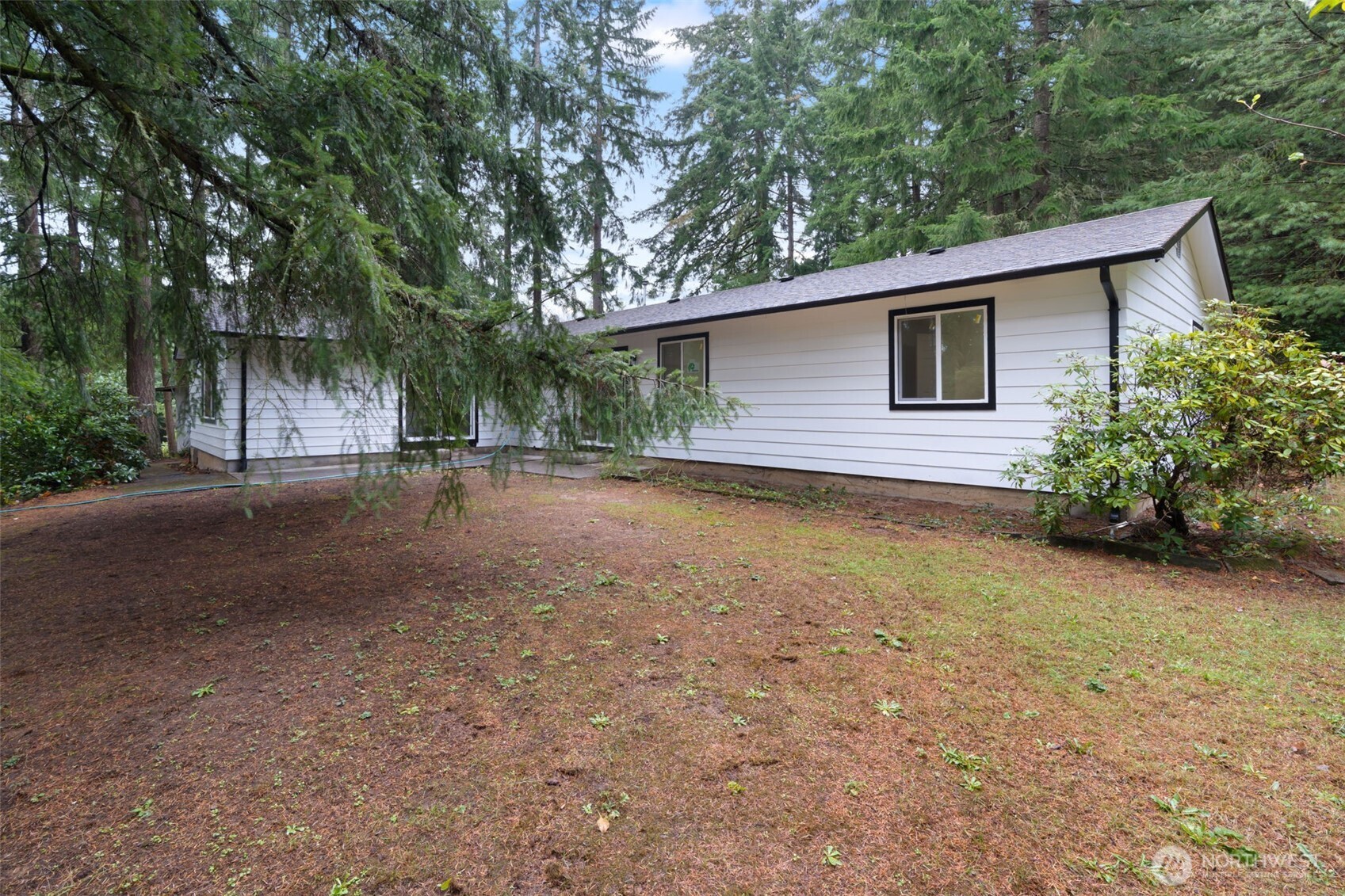 400 Ogden Road Castle Rock, WA 98611 - Photo 25 of 30 a backyard of a house with large trees and brick wall