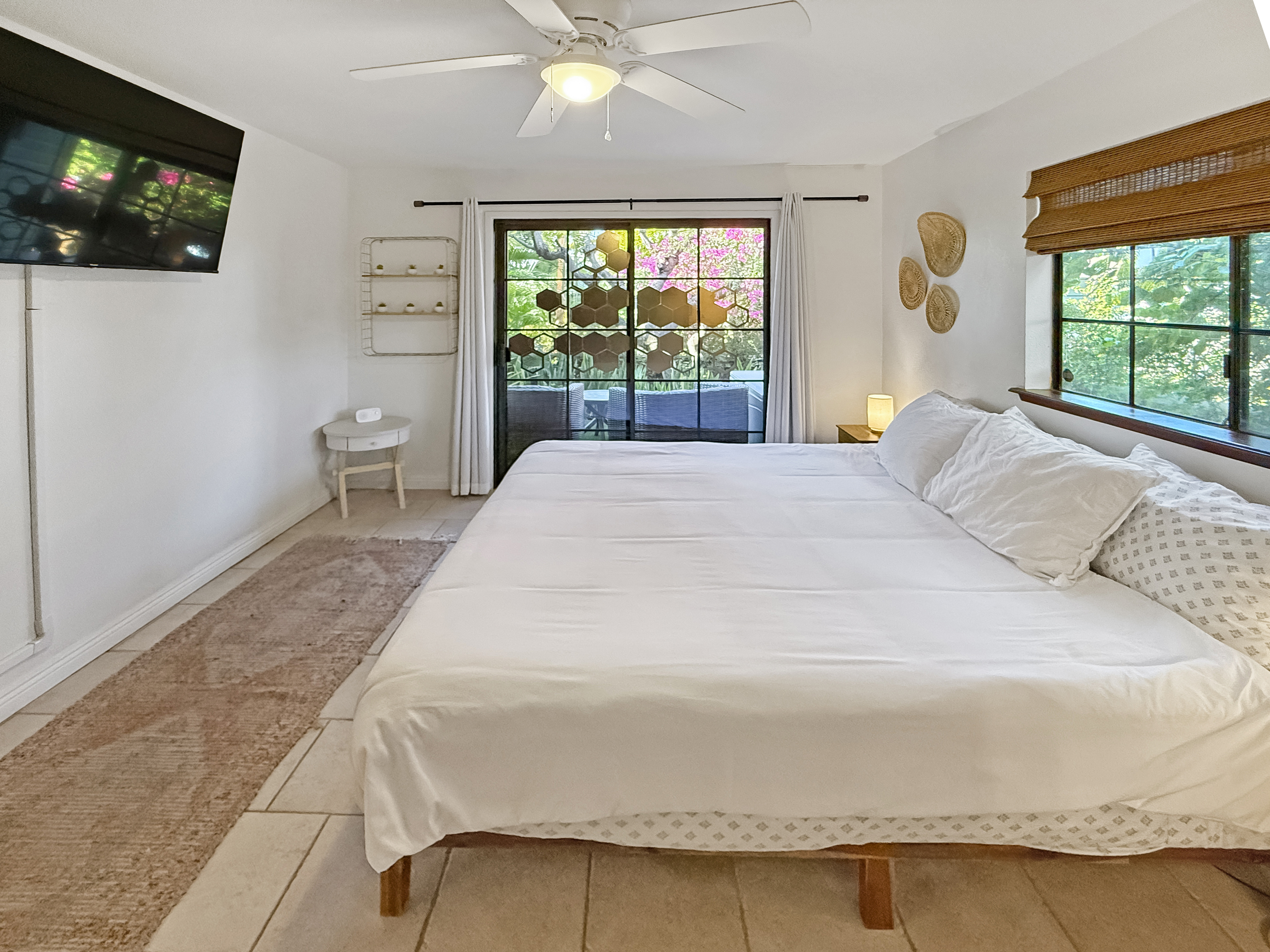 75-123 Lunapule Road, Unit 104 Kailua-Kona, HI 96740 - Photo 14 of 30 a bedroom with a bed and a flat tv screen next to a window