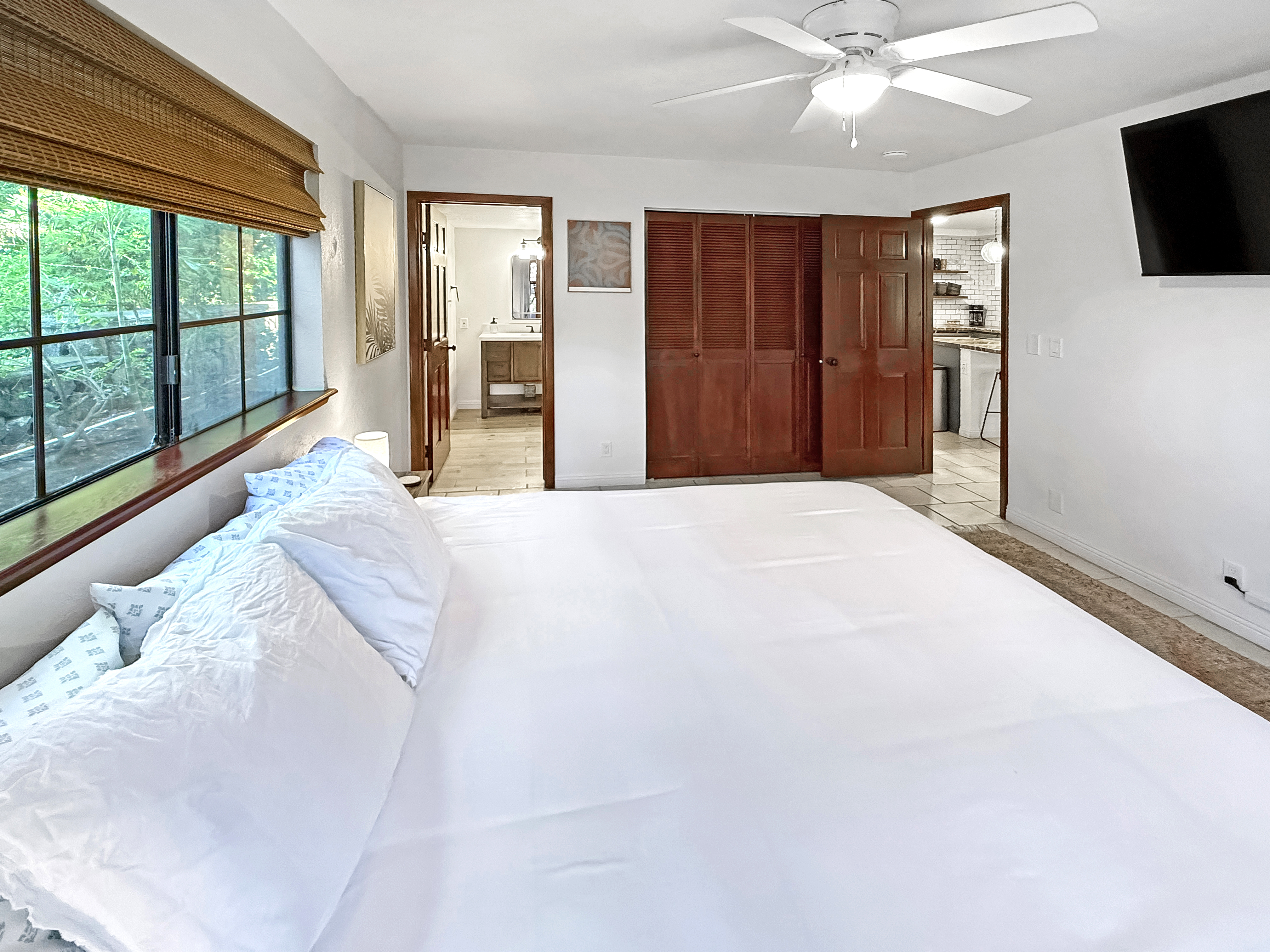 75-123 Lunapule Road, Unit 104 Kailua-Kona, HI 96740 - Photo 16 of 30 a large bedroom with a large bed and a flat tv screen