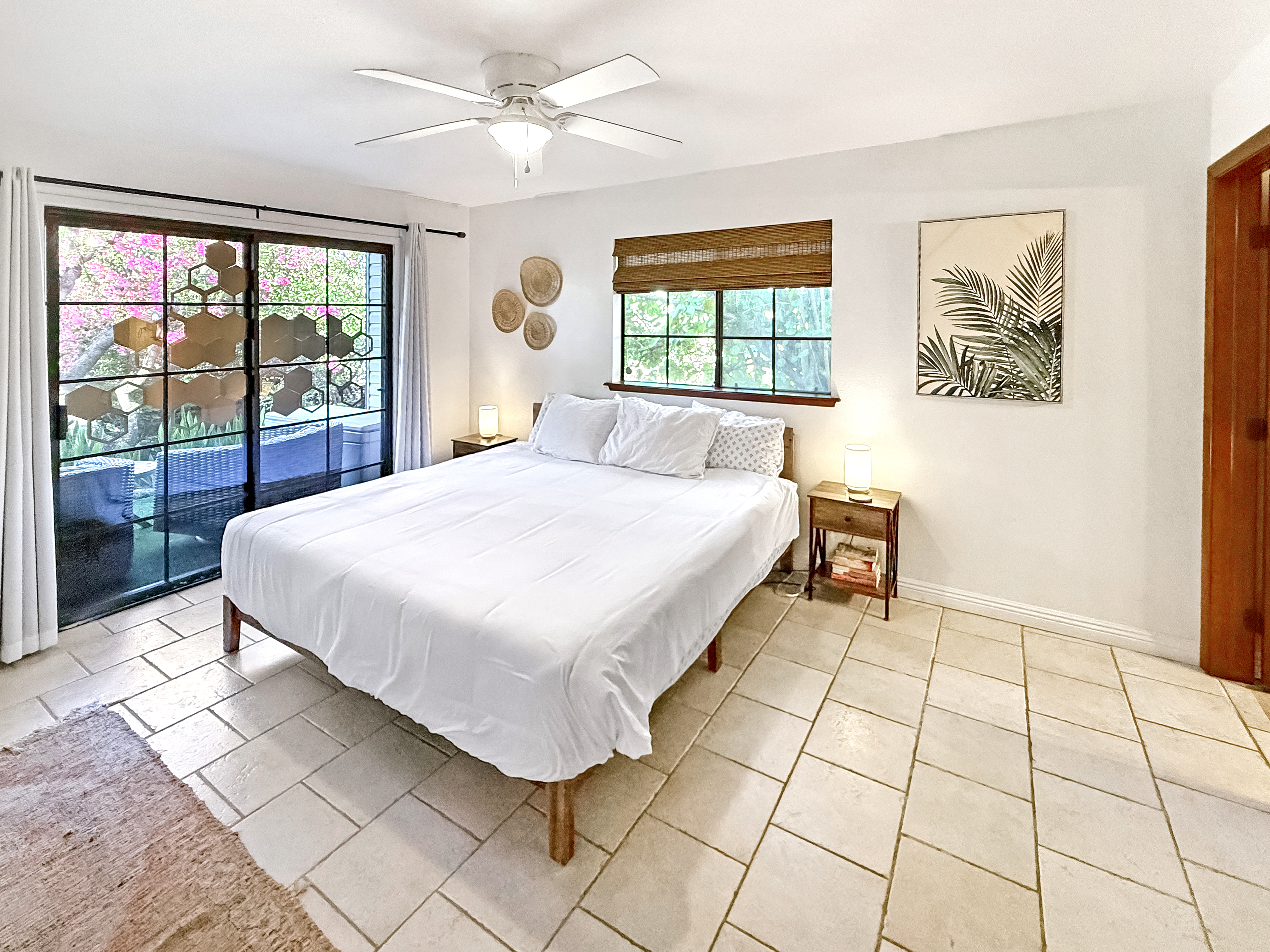 75-123 Lunapule Road, Unit 104 Kailua-Kona, HI 96740 - Photo 17 of 30 a spacious bedroom with a bed painting on wall and a large window