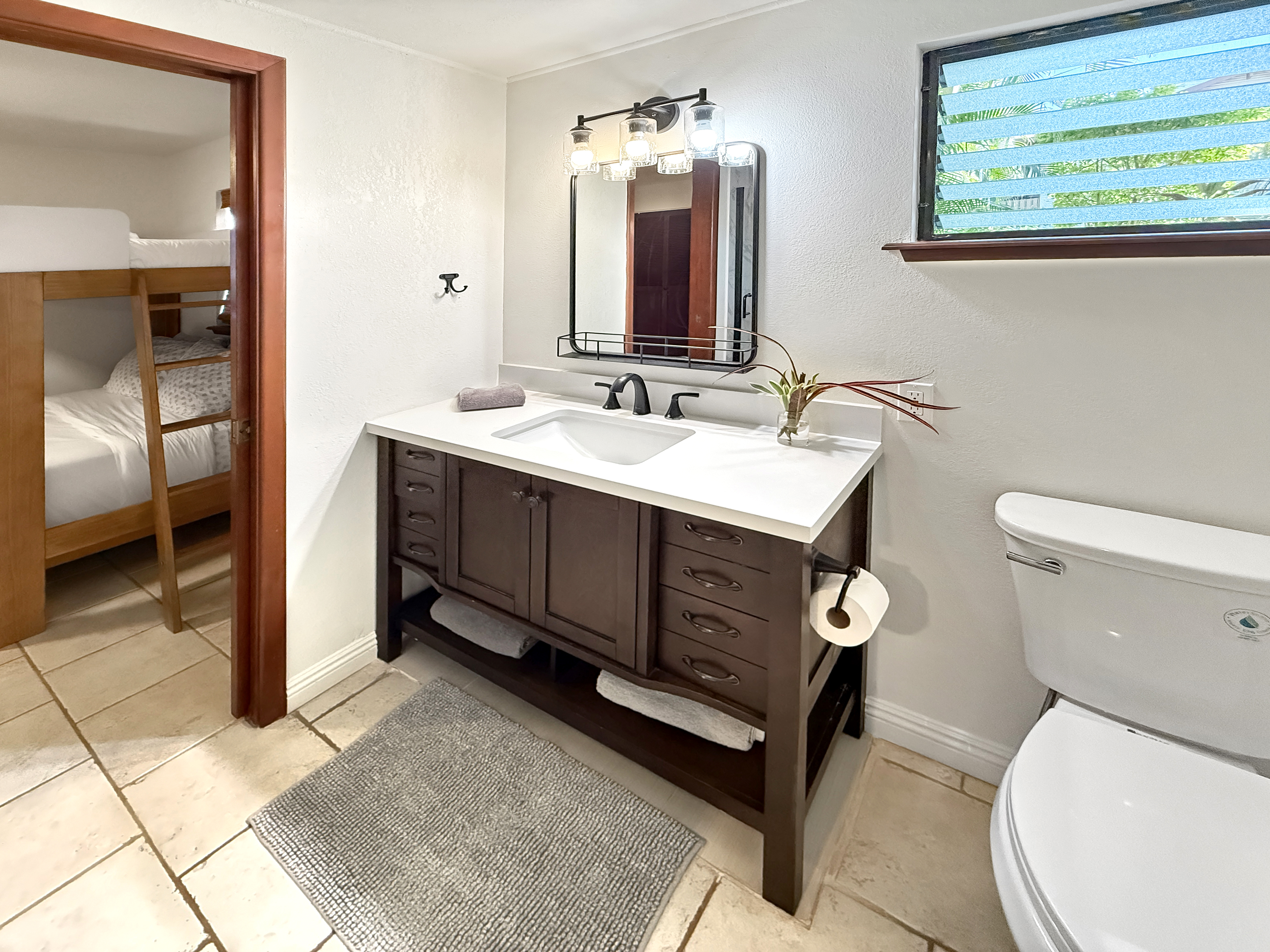 75-123 Lunapule Road, Unit 104 Kailua-Kona, HI 96740 - Photo 24 of 30 a bathroom with a toilet sink and mirror