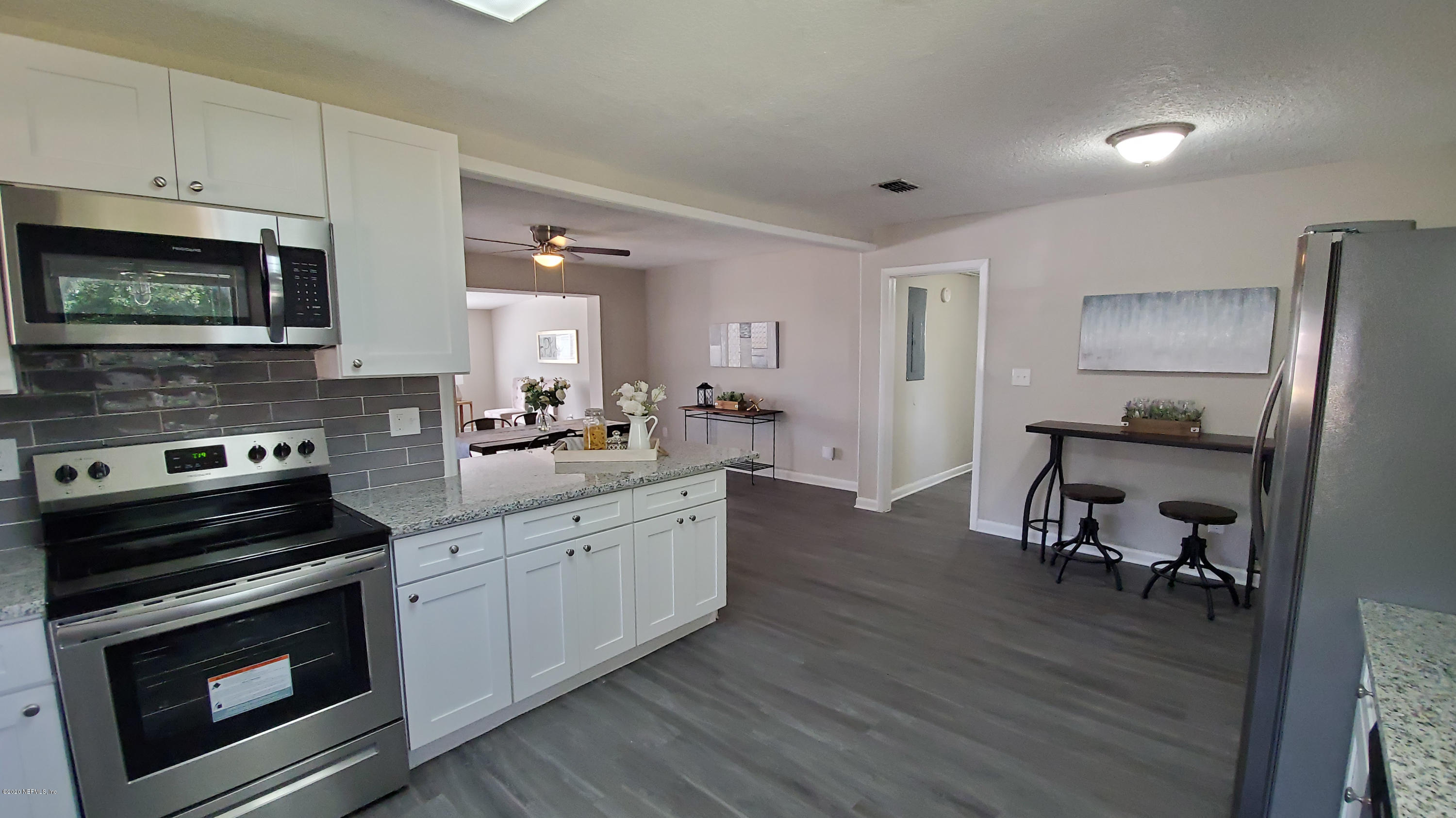 6929 Arques Road Jacksonville, FL 32205 - Photo 17 of 31 a kitchen with stainless steel appliances a stove a sink cabinets and a wooden floor