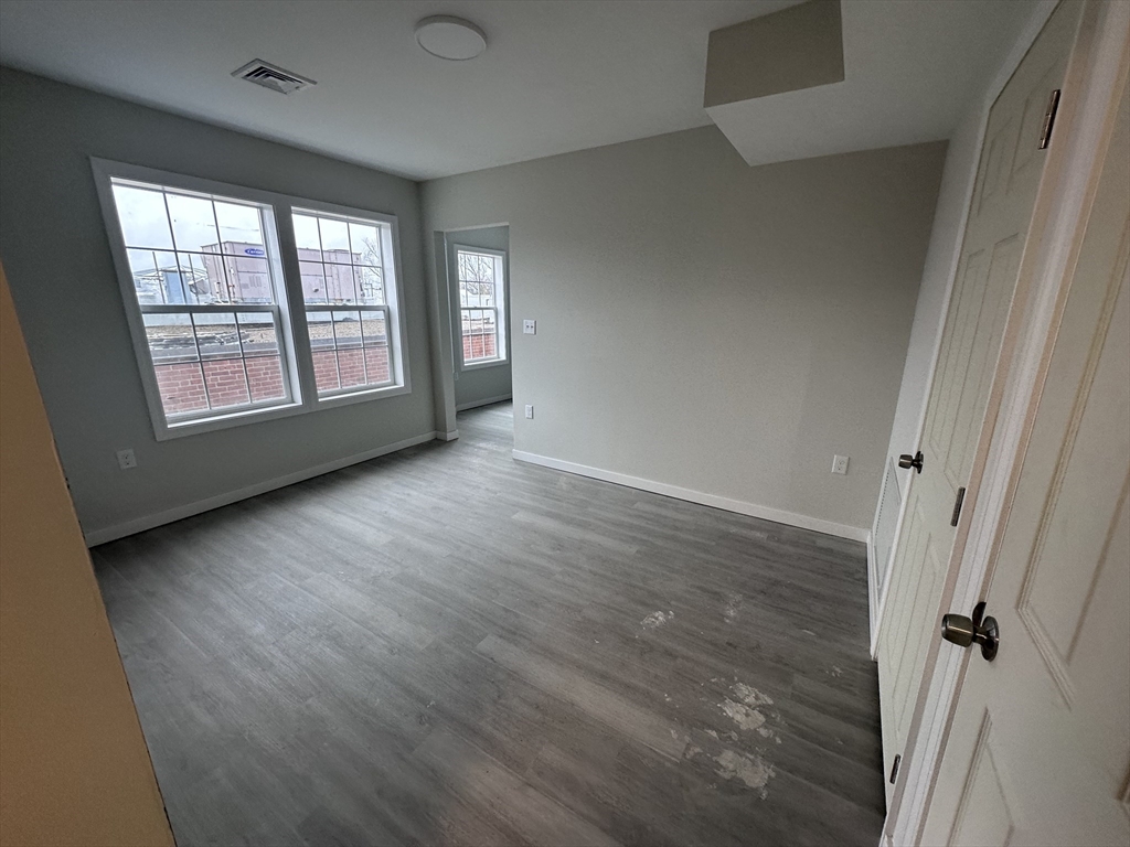 18 Marlborough Street, Unit 2L Chelsea, MA 02150 - Photo 6 of 7 an empty room with wooden floor and windows