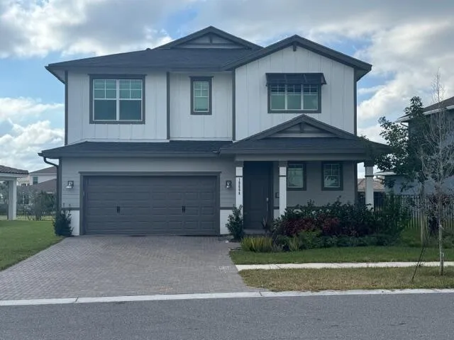 a front view of a house with a garden and garage