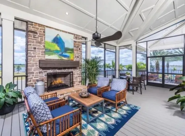 a living room with furniture a fireplace and a floor to ceiling window