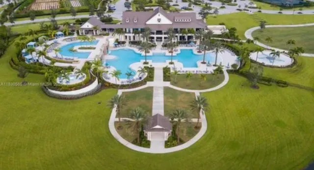 an aerial view of a house with swimming pool and outdoor seating