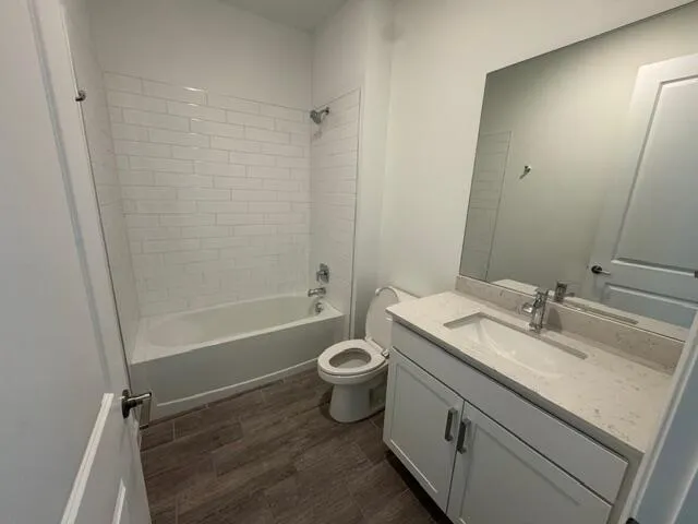 a bathroom with a granite countertop sink a toilet and shower