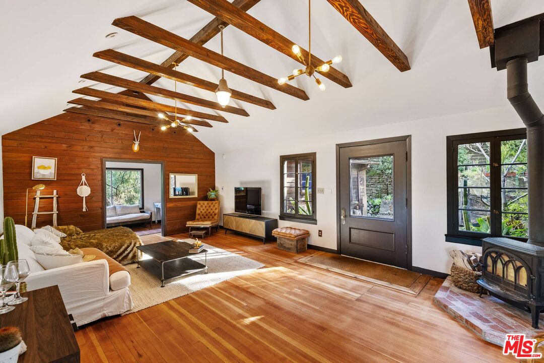 1551 Penny Road Topanga, CA 90290 - Photo 4 of 51 a living room with furniture a fireplace and a flat tv screen next to a window
