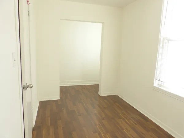 a view of a small space with wooden floor and a window