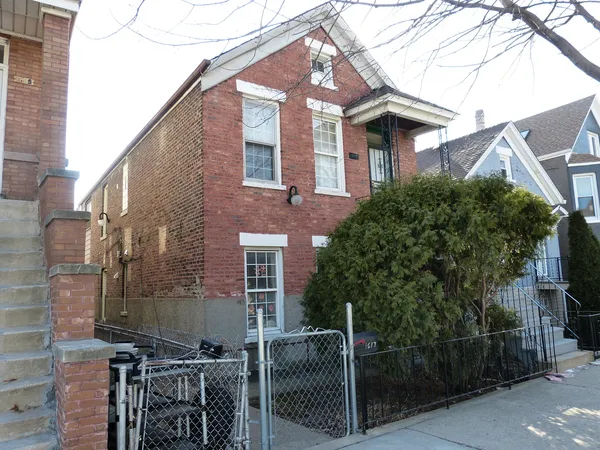 a front view of a house with iron fence