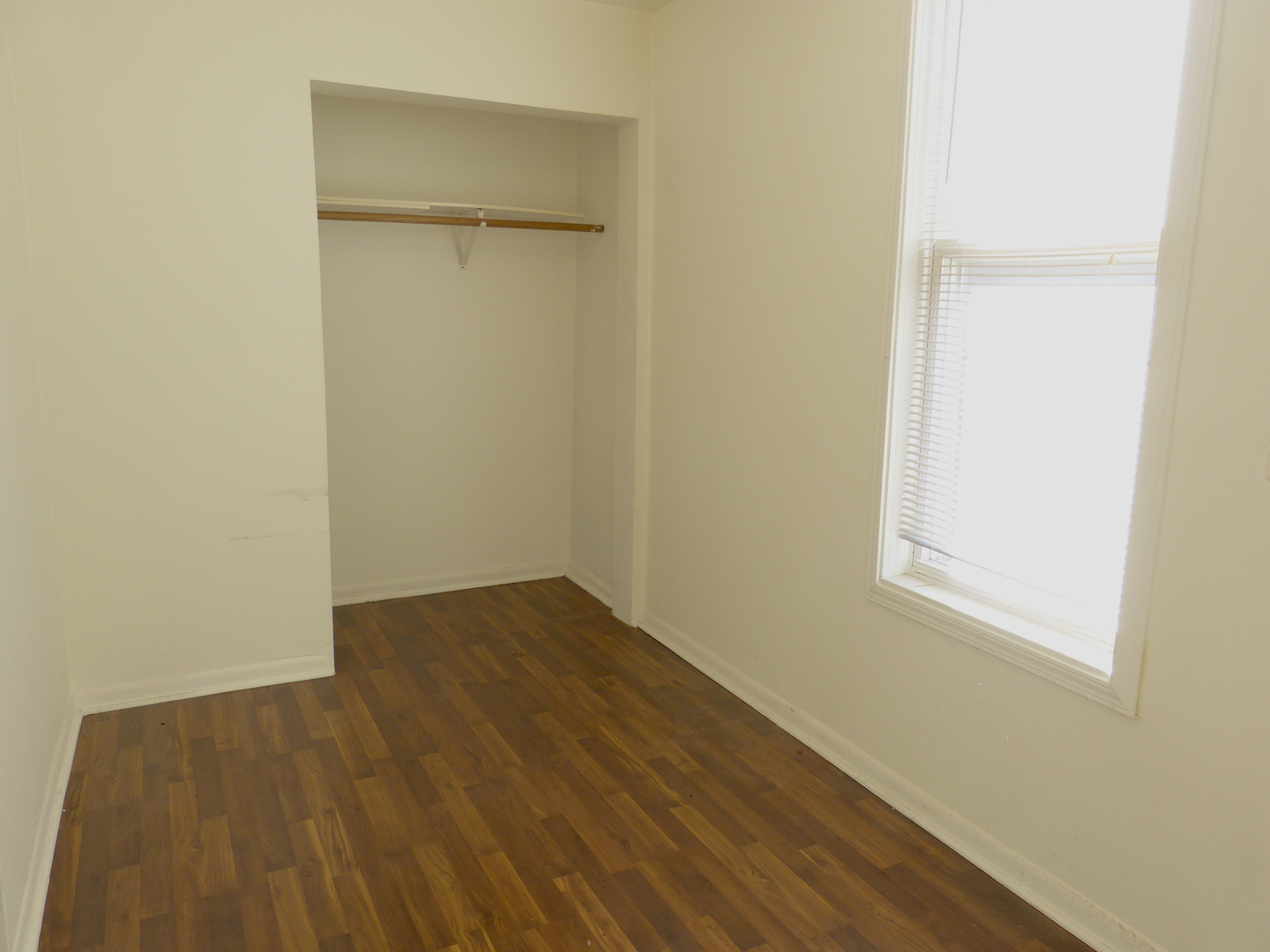 1617 West 38th Place Chicago, IL 60609 - Photo 7 of 18 a view of an empty room with wooden floor and a window