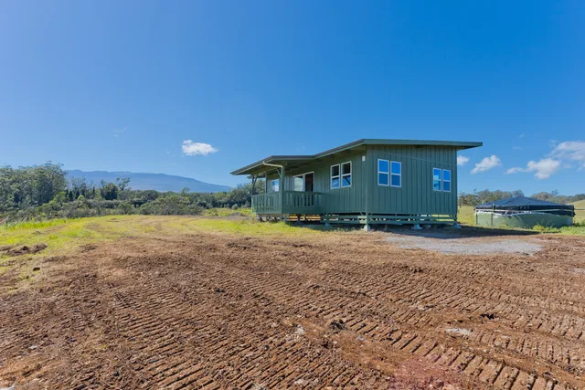 a view of a house with a yard and sitting area