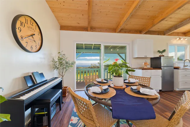 a view of a dining room with furniture a potted plant and wooden floor