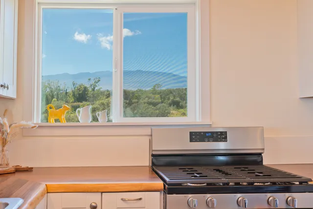 a stove top oven sitting next to a window