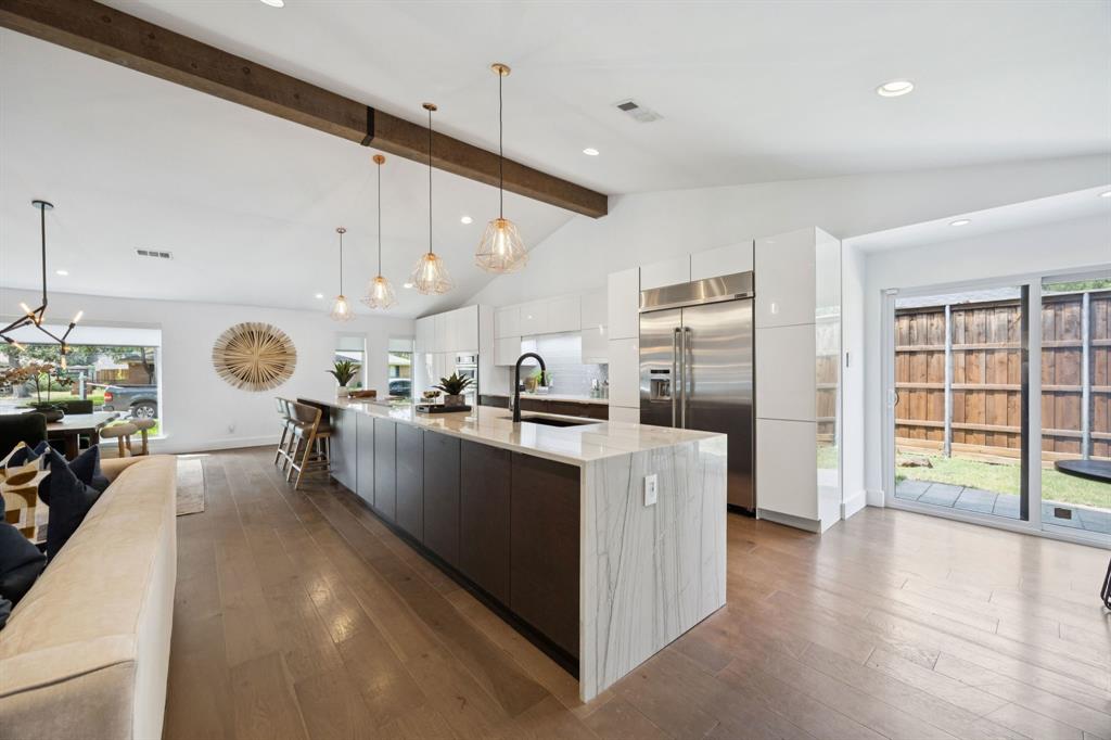 4925 Sugar Mill Road Dallas, TX 75244 - Photo 4 of 22 a large kitchen with stainless steel appliances kitchen island a large counter top and a wooden floors