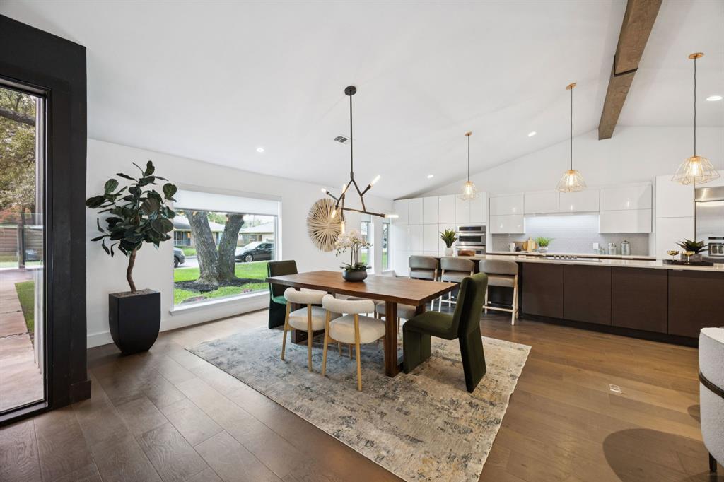 4925 Sugar Mill Road Dallas, TX 75244 - Photo 7 of 22 a view of a dining room and livingroom with furniture wooden floor a rug a fireplace and a chandelier