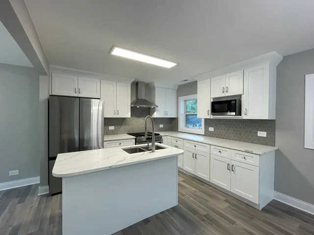 a kitchen with stainless steel appliances a refrigerator stove microwave and sink