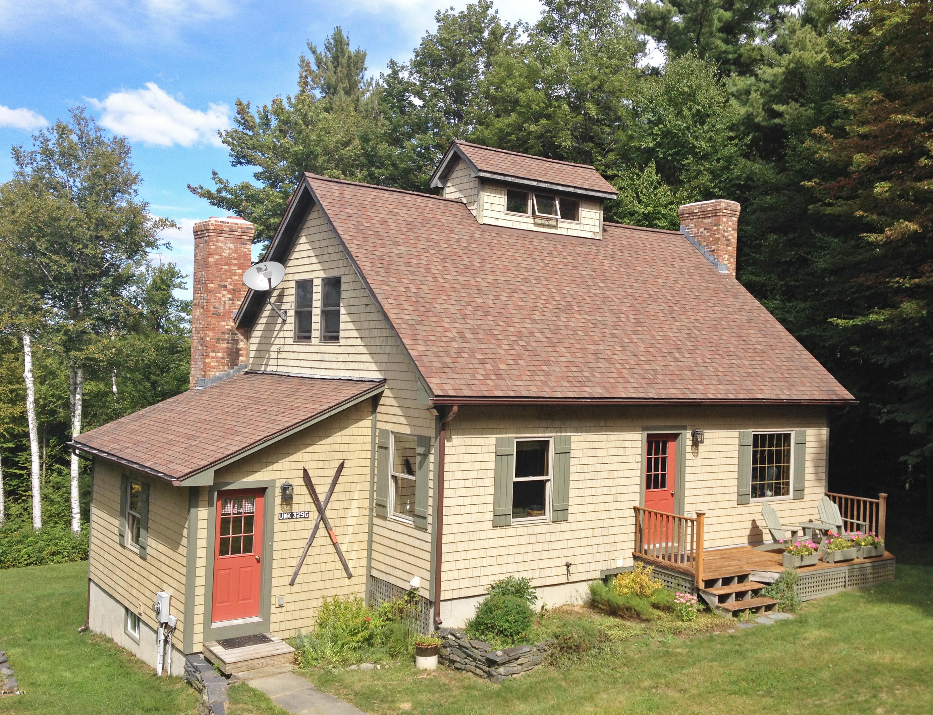 a front view of a house with a garden and yard