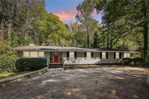 a front view of house with yard and trees around