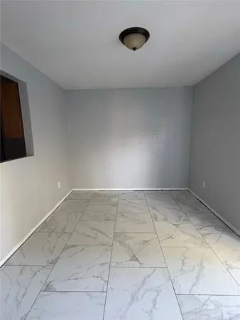 a view of a room with an empty space and a window