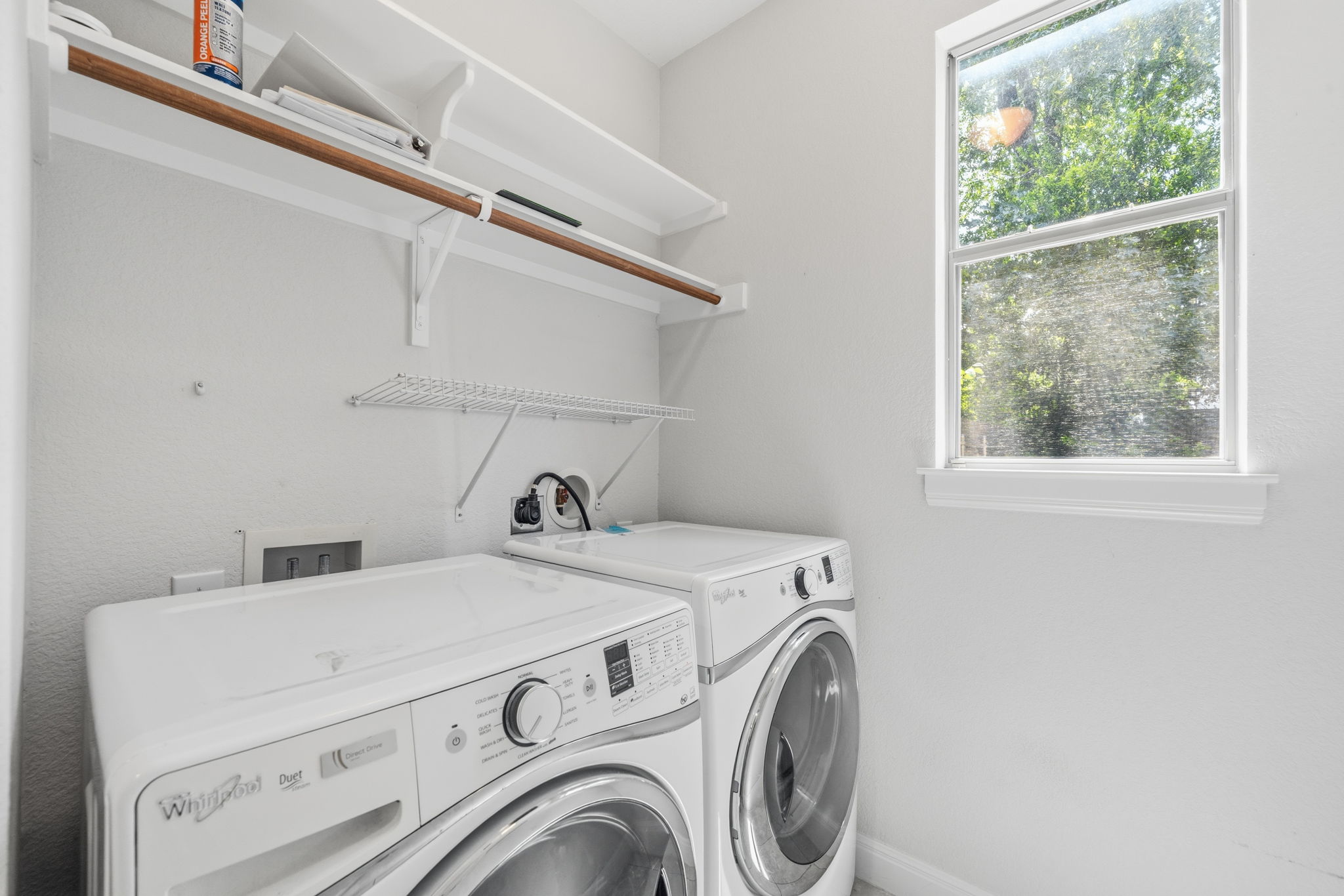 6708 Manchaca Road, Unit 4 Austin, TX 78745 - Photo 11 of 25 Functional laundry space features a bright window and built-in shelving overhead.