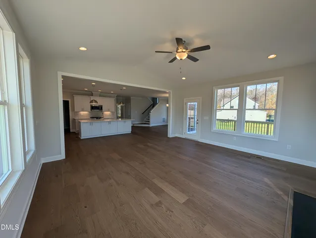 a large kitchen with stainless steel appliances a large counter top a stove and a refrigerator