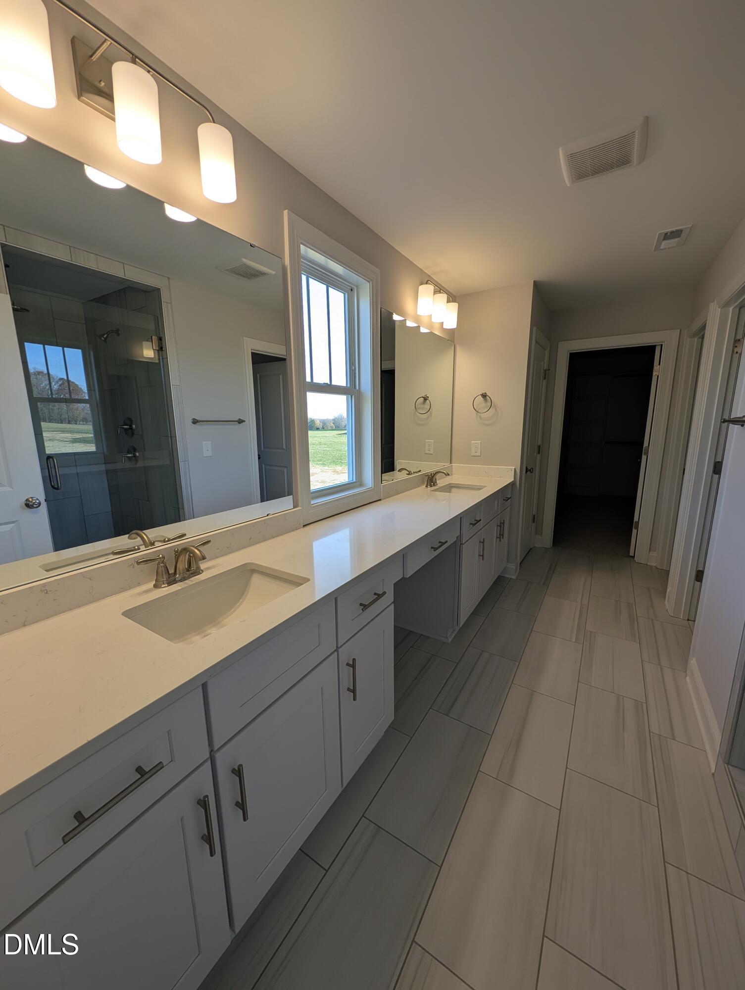 2818 John Lewis Road Burlington, NC 27217 - Photo 33 of 62 a spacious bathroom with a double vanity sink and a mirror