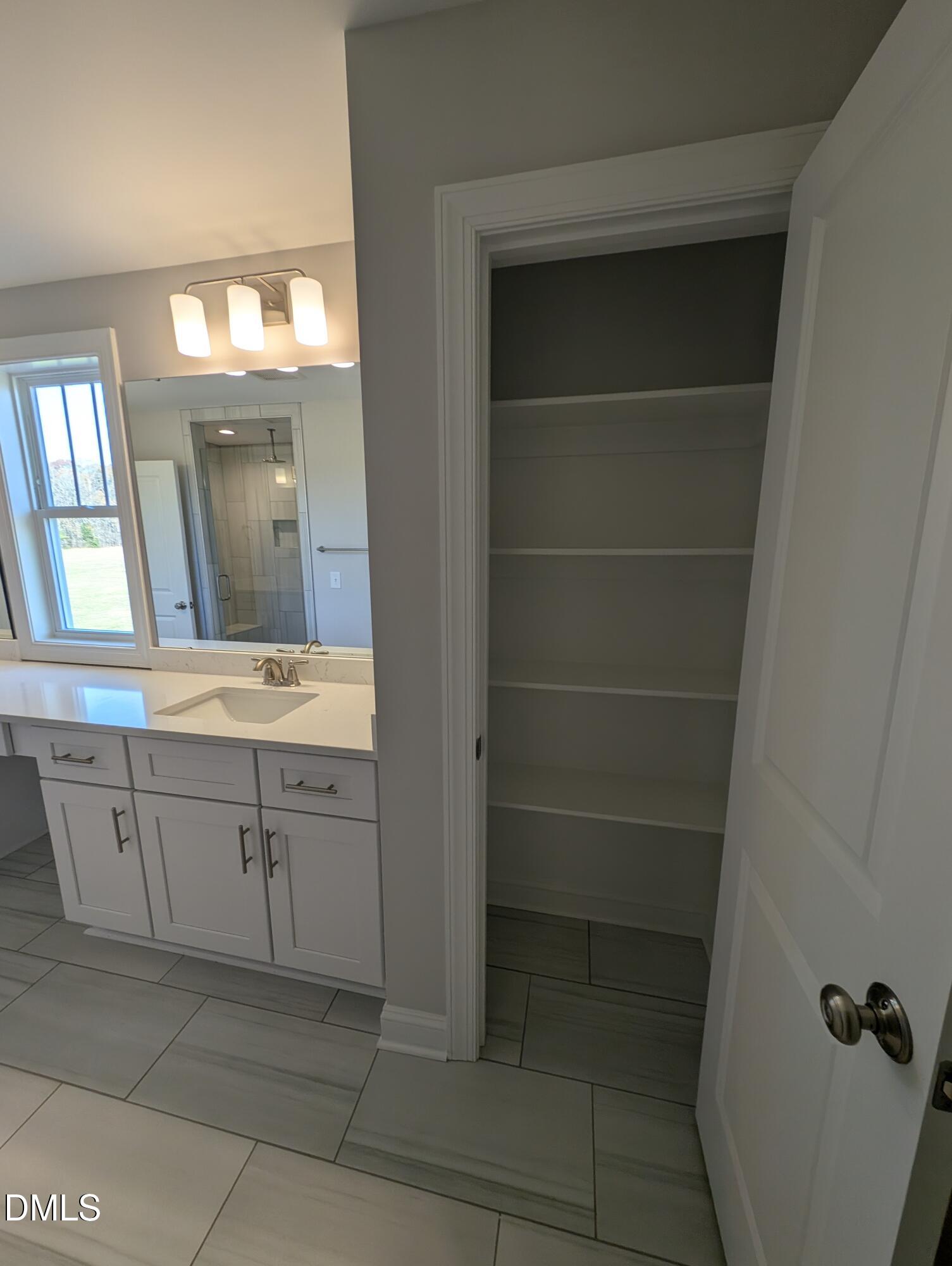 2818 John Lewis Road Burlington, NC 27217 - Photo 41 of 62 a bathroom with a vanity a sink a mirror and a bathtub