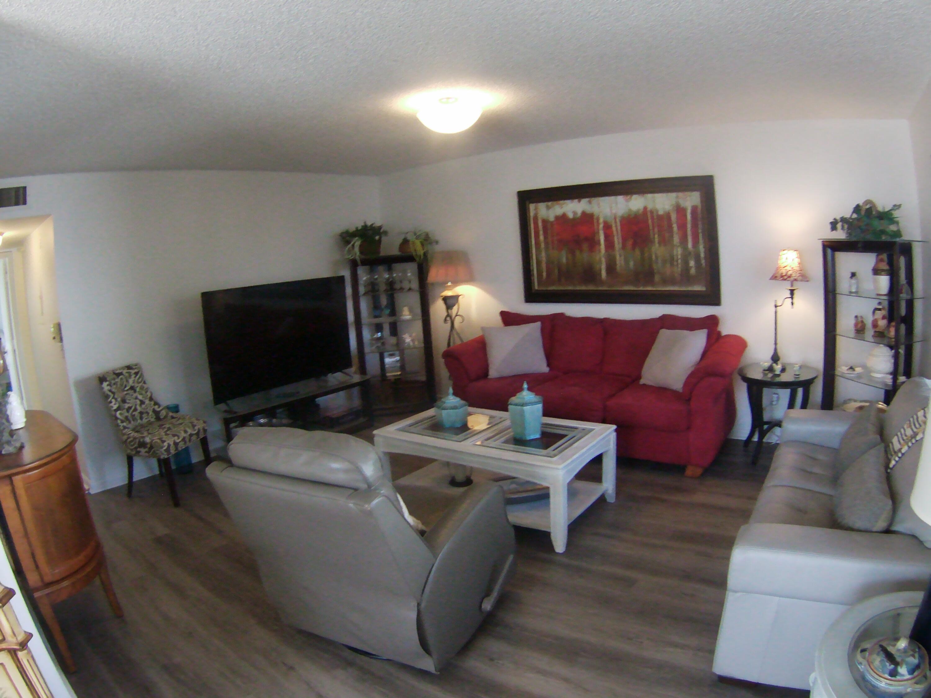 a living room with furniture a flat screen tv and a window