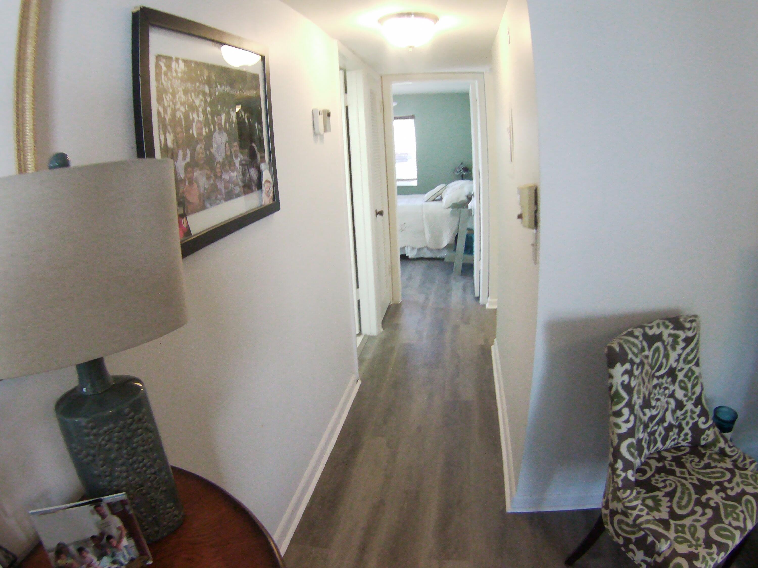 571 Capri L Delray Beach, FL 33484 - Photo 13 of 33 a hallway with wooden floor and a chair