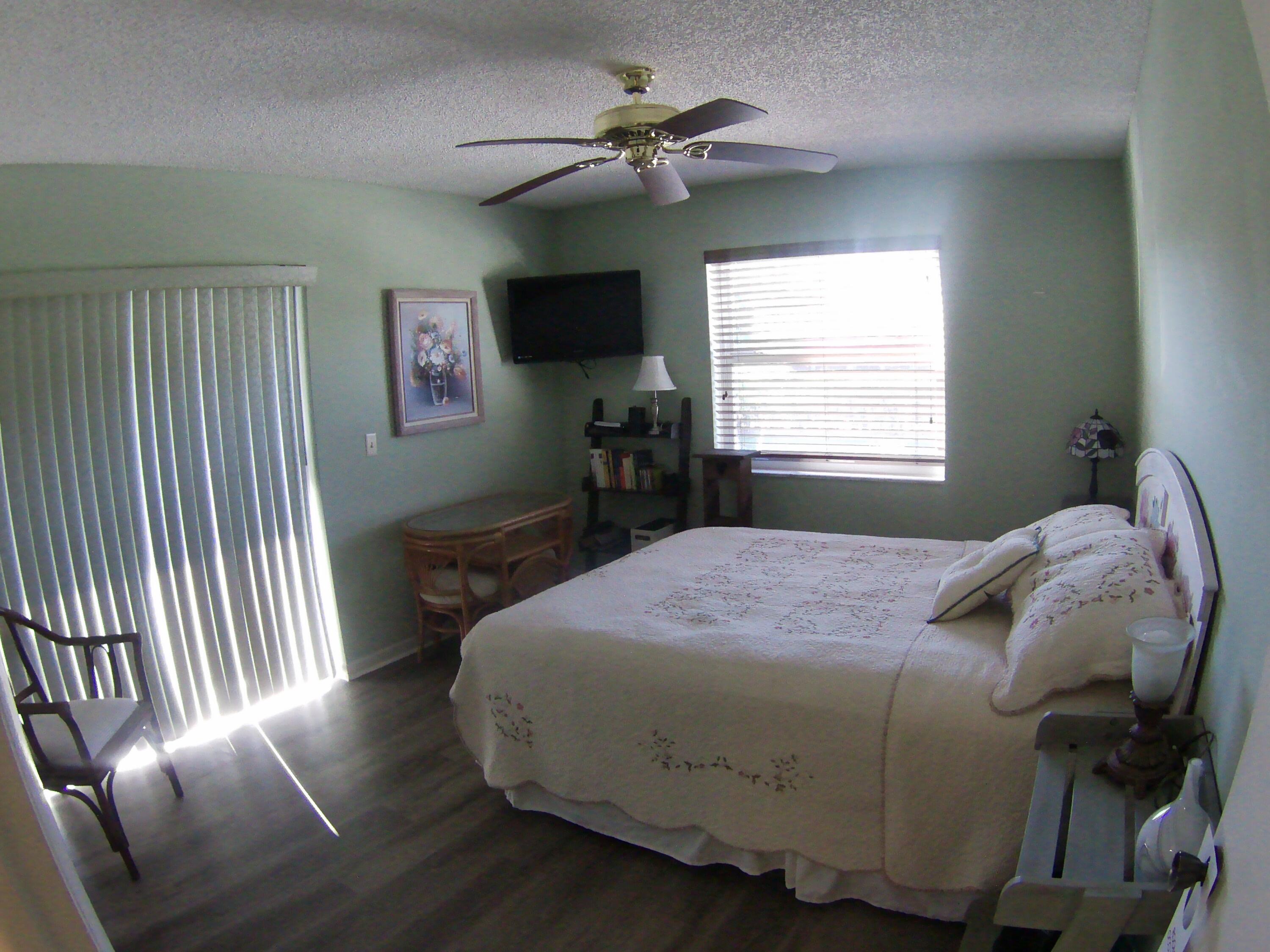 571 Capri L Delray Beach, FL 33484 - Photo 17 of 33 a bedroom with a bed and a chandelier