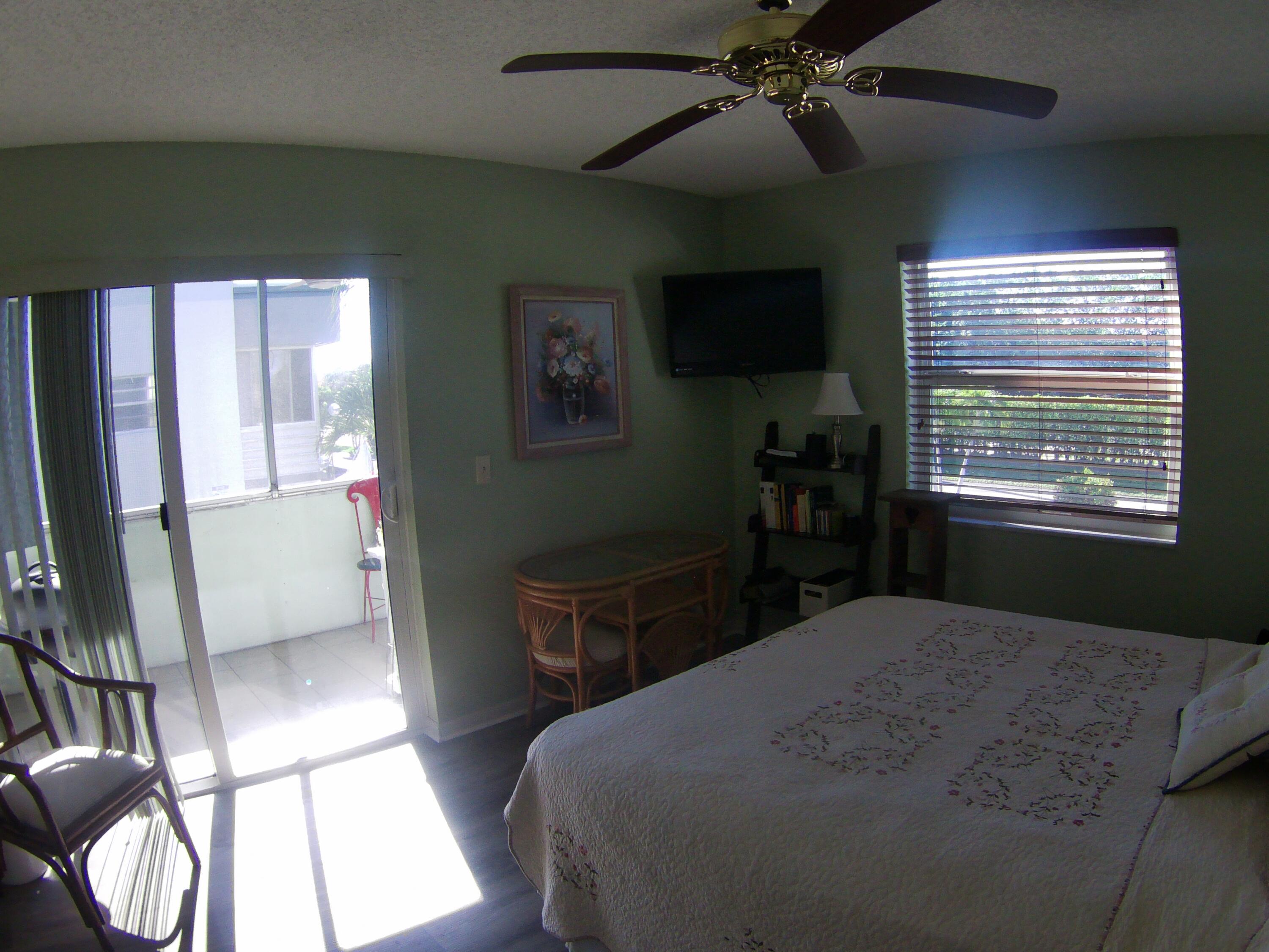 571 Capri L Delray Beach, FL 33484 - Photo 19 of 33 a bedroom with a bed and a chandelier