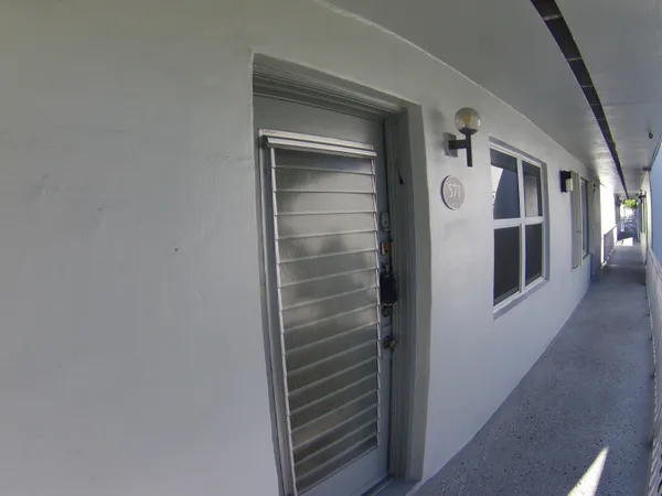 a view of a balcony with floor to ceiling windows and wooden fence