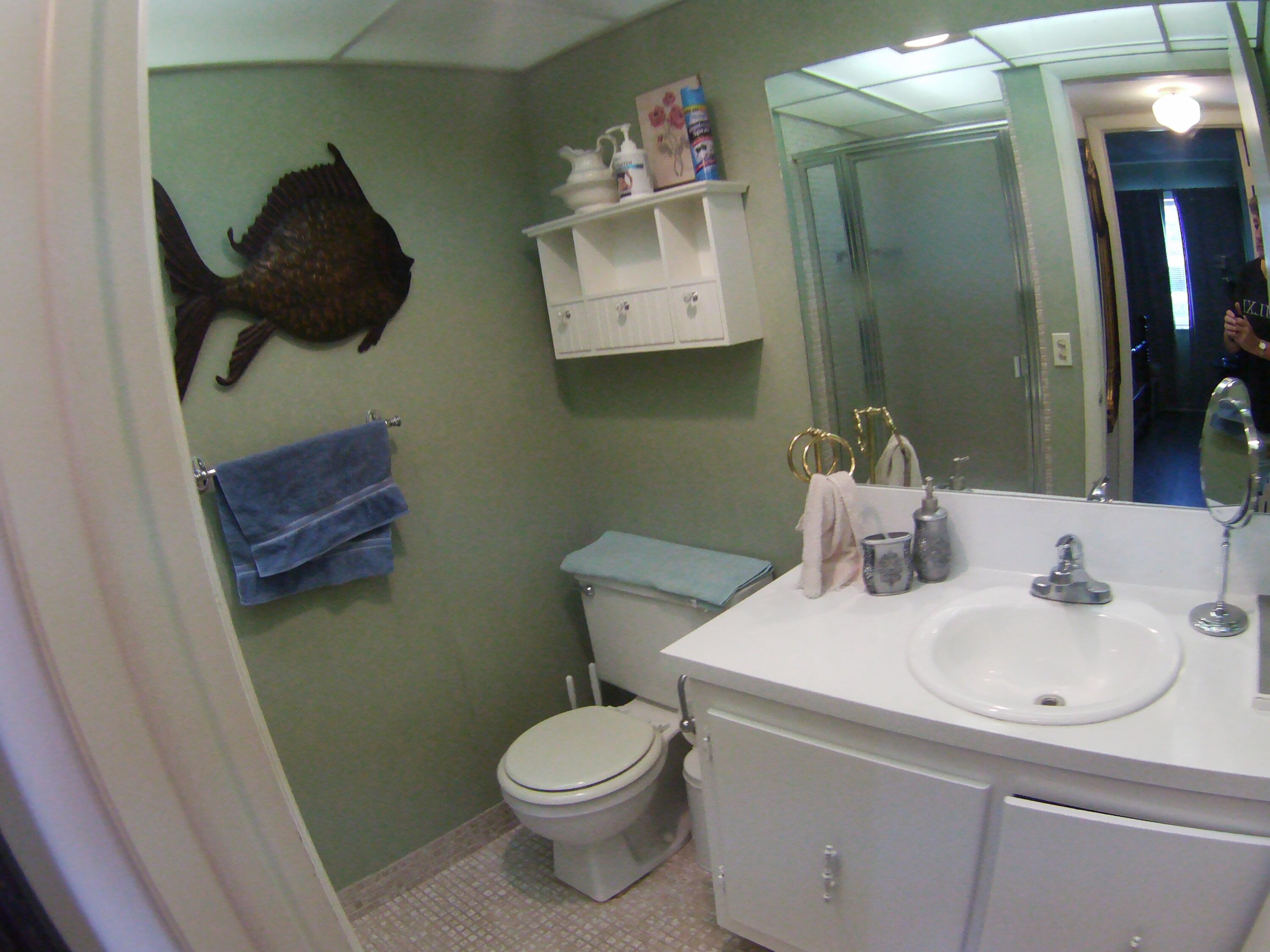 571 Capri L Delray Beach, FL 33484 - Photo 21 of 33 a bathroom with a toilet sink and mirror