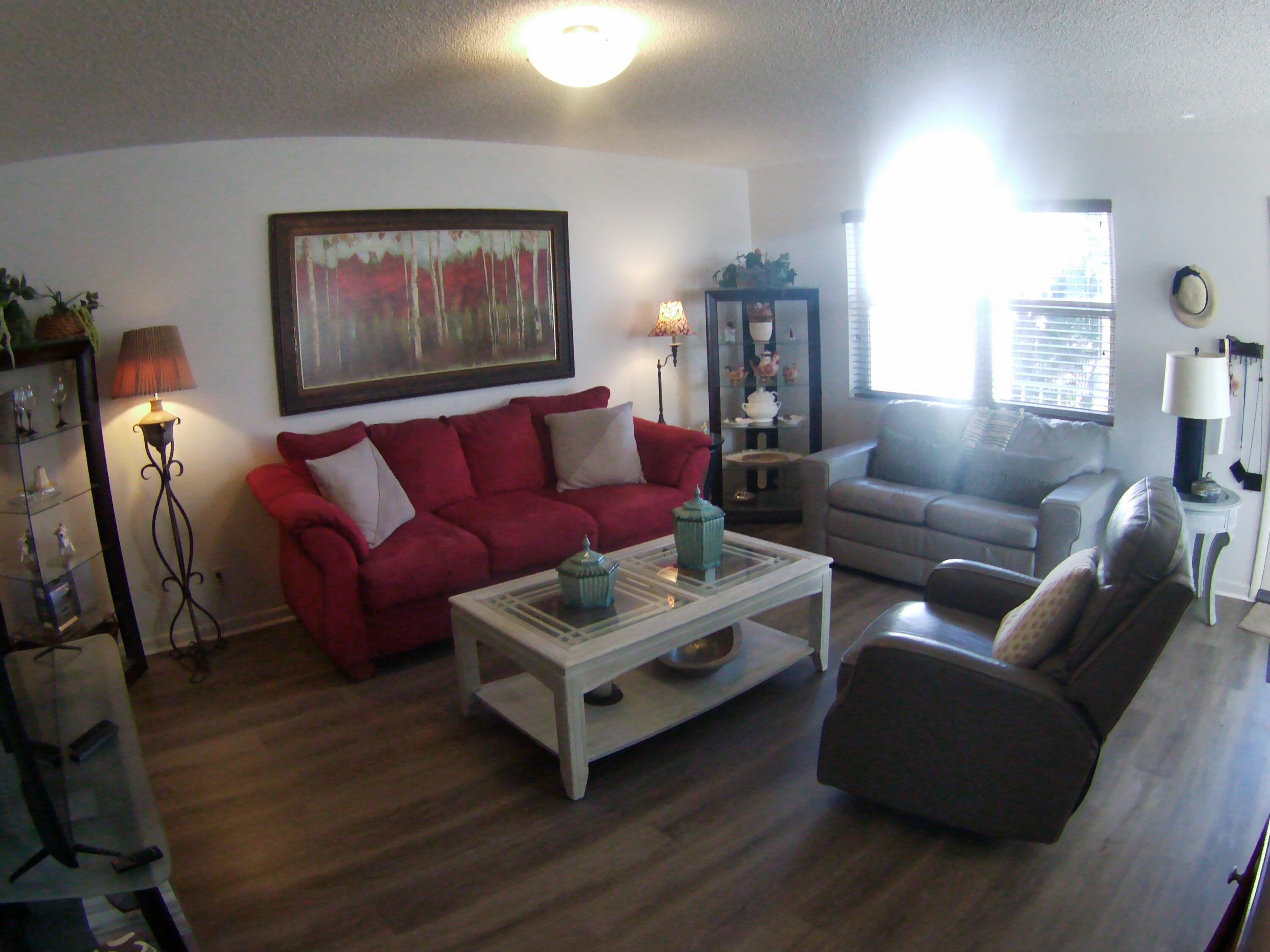 571 Capri L Delray Beach, FL 33484 - Photo 4 of 33 a living room with furniture a wooden floor and a large window