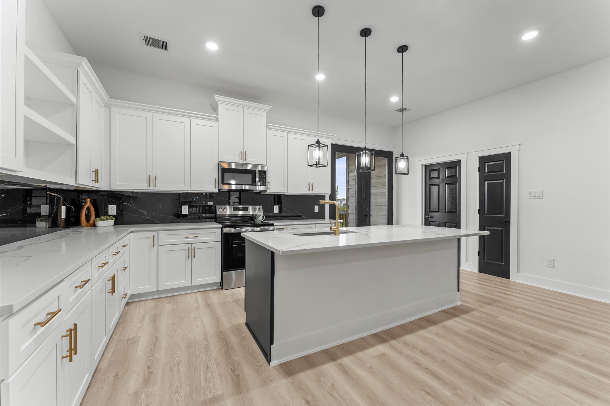 1133 Longleaf Pne Street Huffman, TX 77336 - Photo 9 of 25 Stunning modern kitchen with a massive center island—ideal for cooking or entertaining.