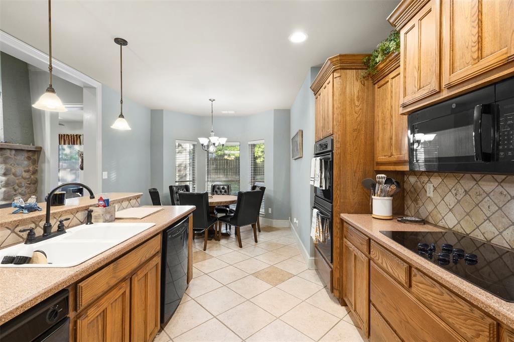 105 Country Ridge Court Red Oak, TX 75154 - Photo 15 of 40 a kitchen with stainless steel appliances granite countertop a sink a stove and a refrigerator