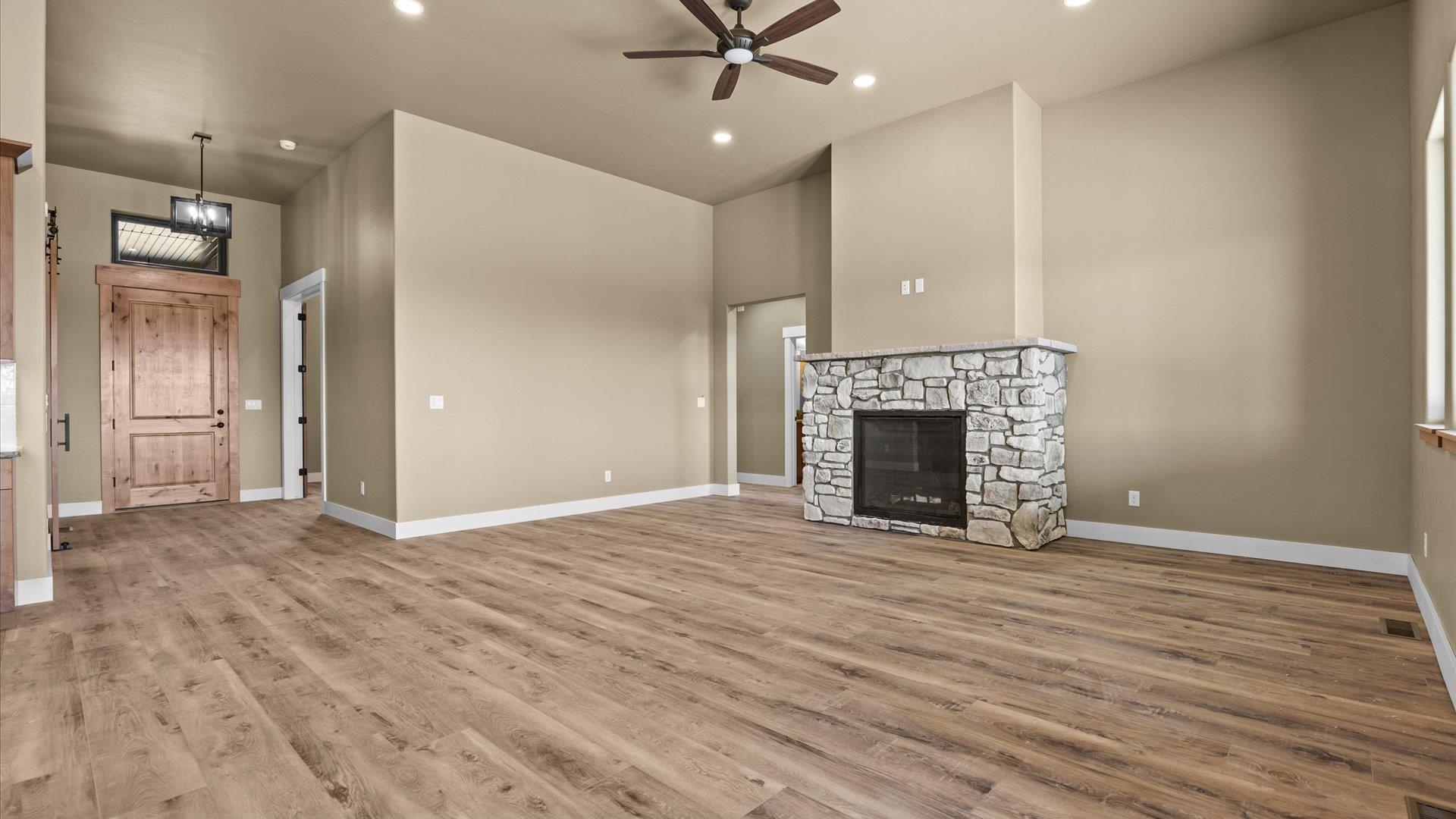 1193 22 1/2 Road Grand Junction, CO 81505 - Photo 4 of 28 an empty room with wooden floor a fireplace and windows