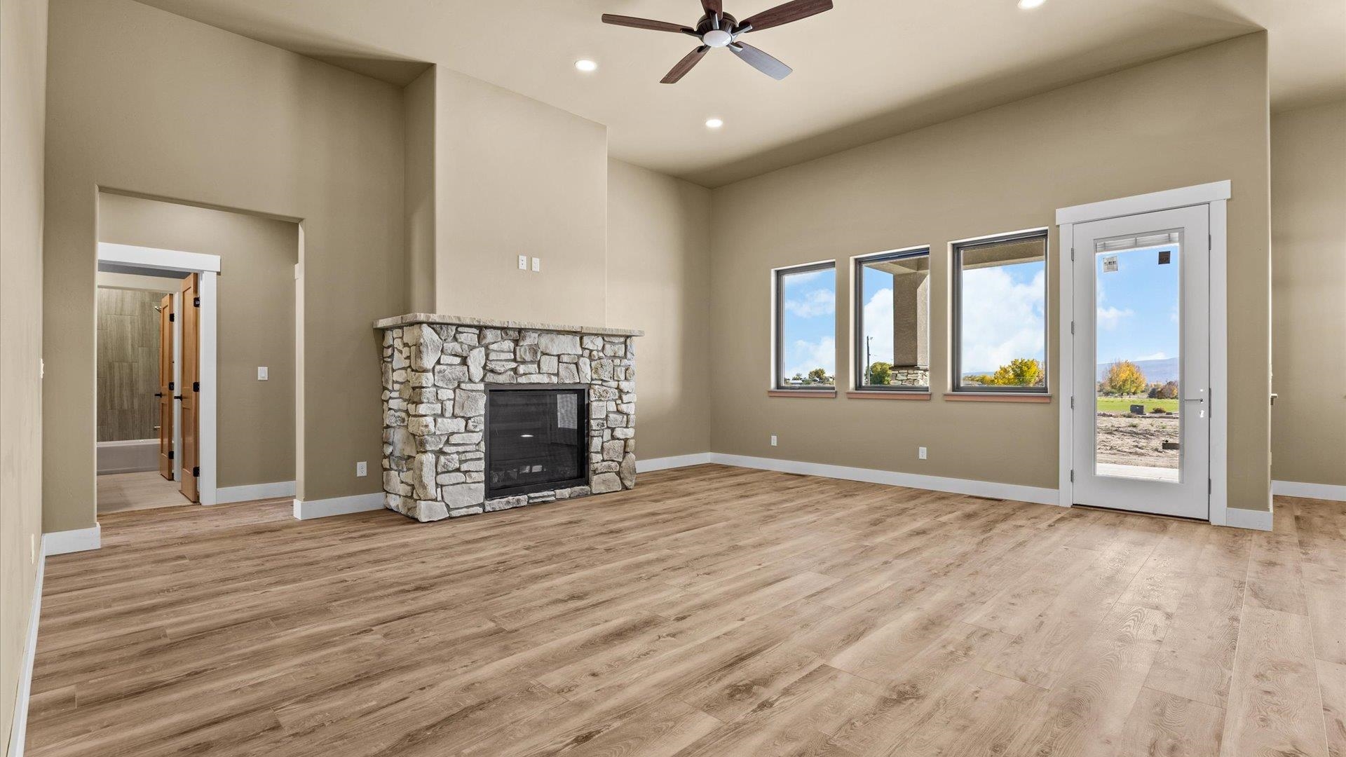 1193 22 1/2 Road Grand Junction, CO 81505 - Photo 5 of 28 an empty room with windows fireplace and wooden floor