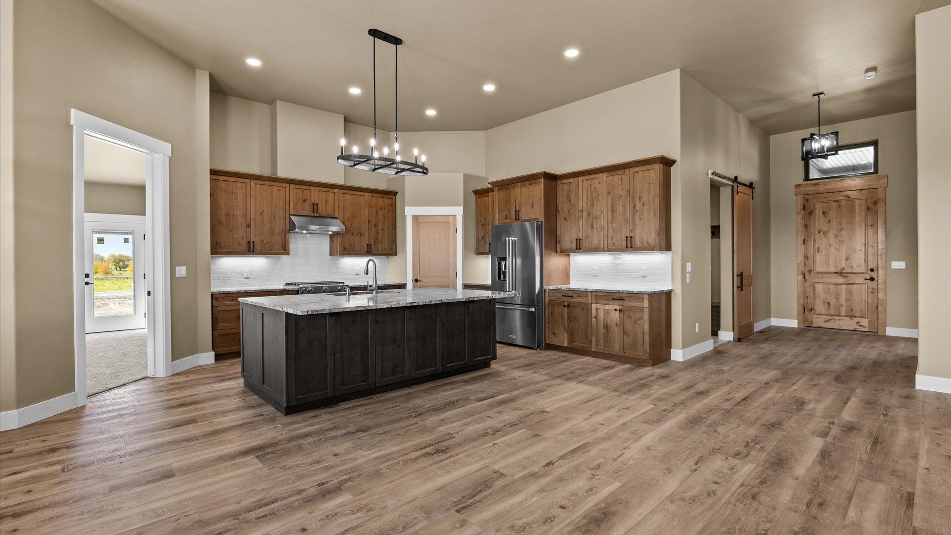 1193 22 1/2 Road Grand Junction, CO 81505 - Photo 7 of 28 a large kitchen with a center island wooden floor stainless steel appliances and cabinets