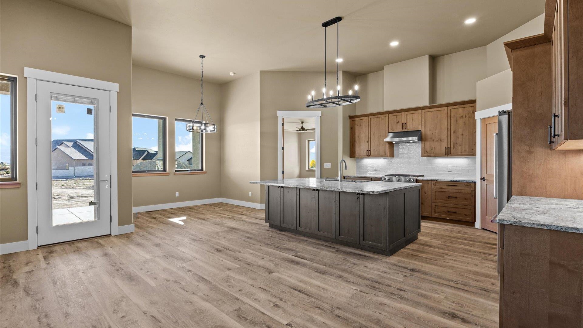 1193 22 1/2 Road Grand Junction, CO 81505 - Photo 9 of 28 a kitchen with stainless steel appliances granite countertop a refrigerator a sink dishwasher a oven and a large island with wooden floor