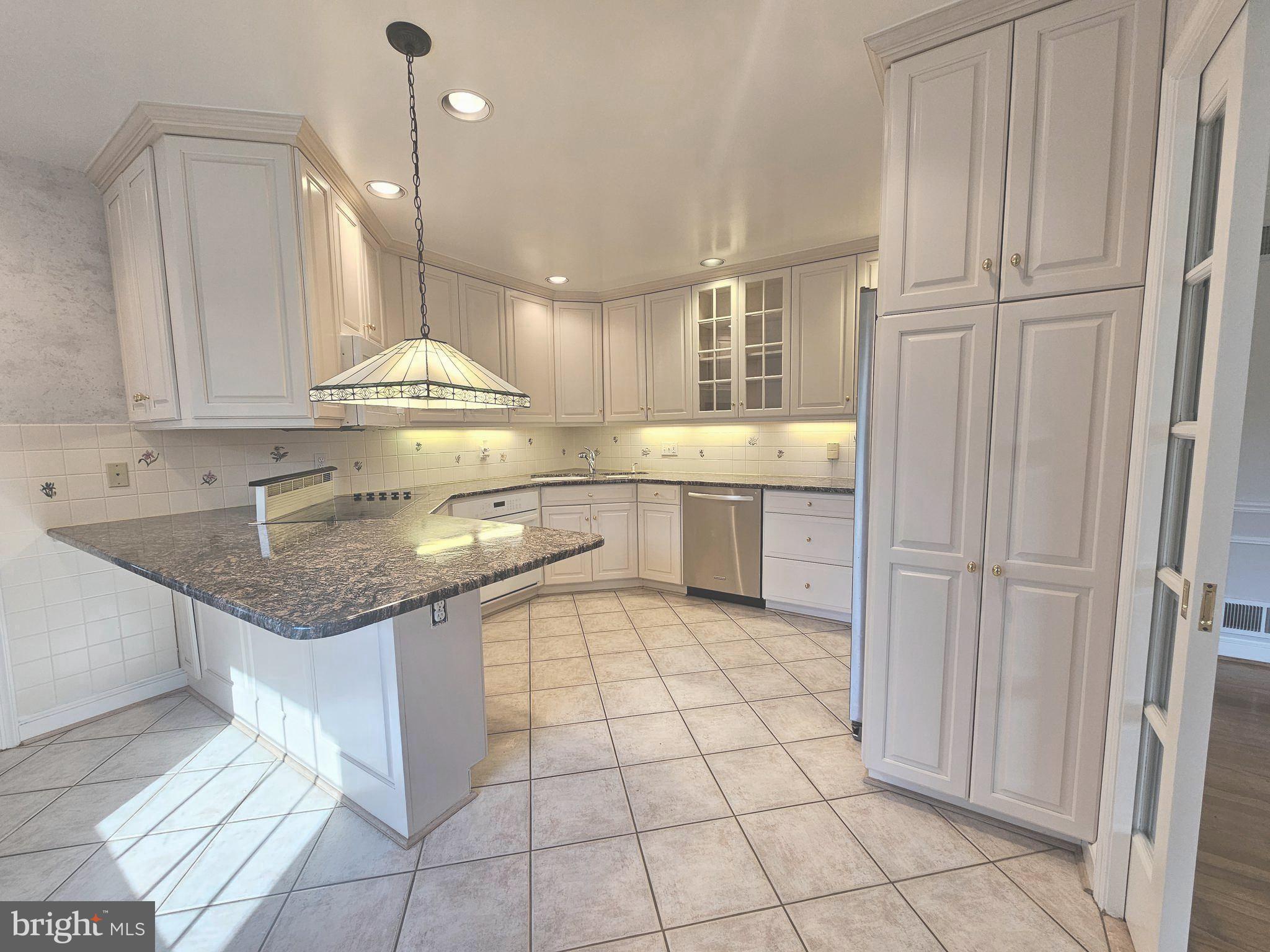 851 Canal Drive McLean, VA 22102 - Photo 7 of 50 a kitchen with kitchen island granite countertop a sink a counter top space and cabinets