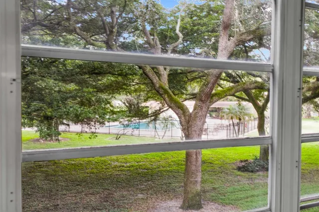 a view of a room with a large window and wooden floor