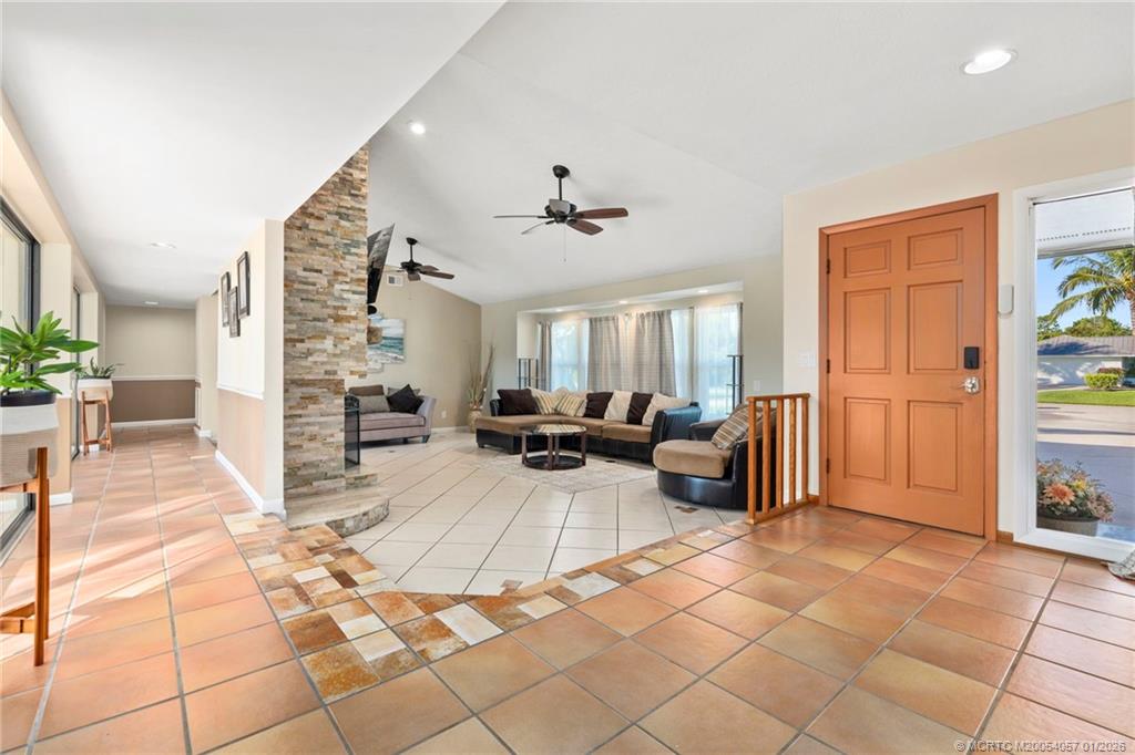 4599 Southeast Halston Court Stuart, FL 34997 - Photo 11 of 65 a living room with furniture and a dining table with kitchen view