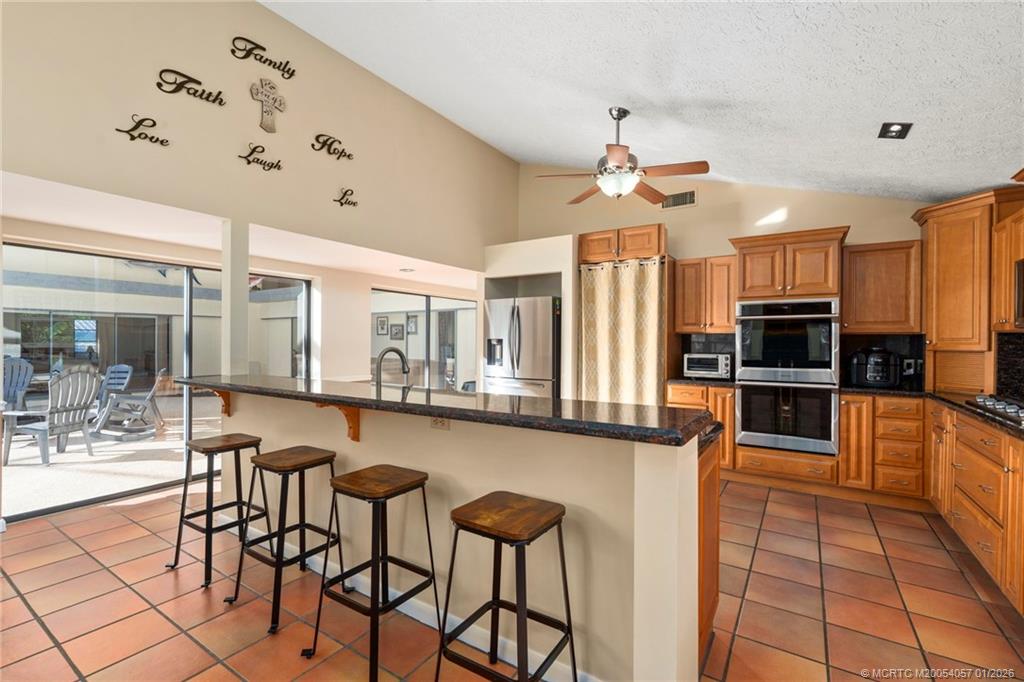4599 Southeast Halston Court Stuart, FL 34997 - Photo 20 of 65 a kitchen with stainless steel appliances granite countertop a stove and cabinets