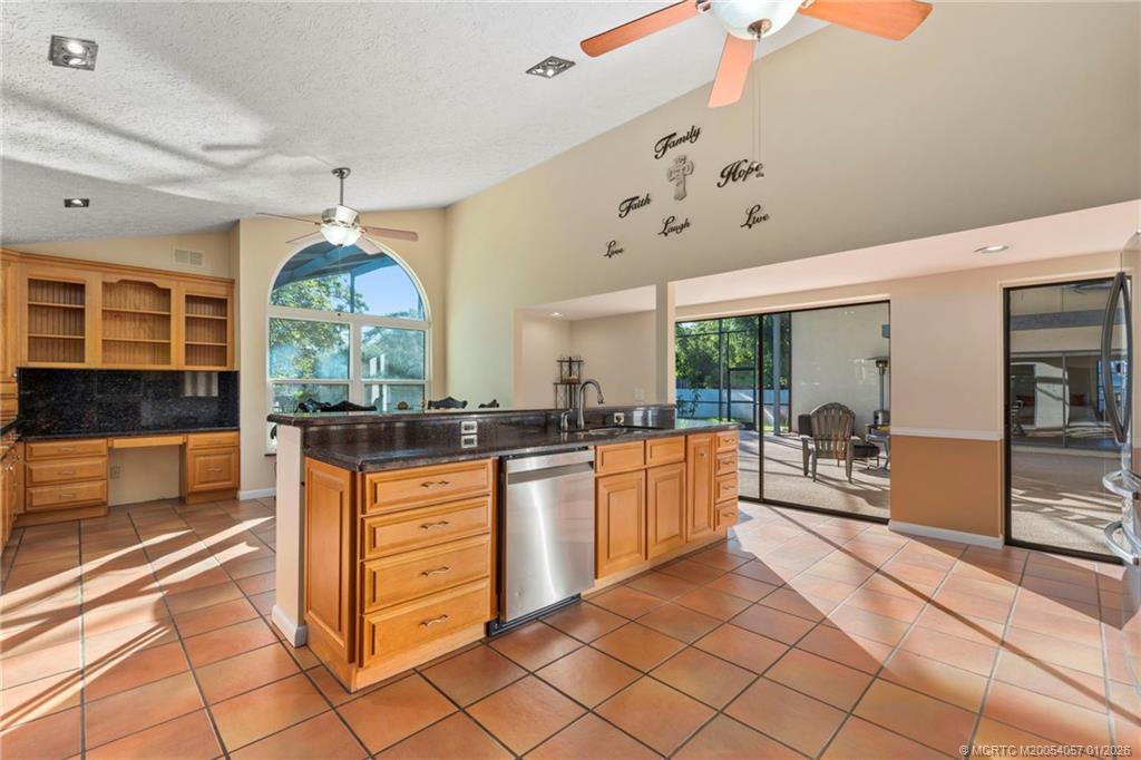 4599 Southeast Halston Court Stuart, FL 34997 - Photo 22 of 65 a kitchen with stainless steel appliances kitchen island granite countertop a stove a sink and a refrigerator